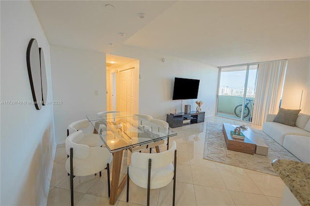 dining room with light tile patterned flooring and a wall of windows