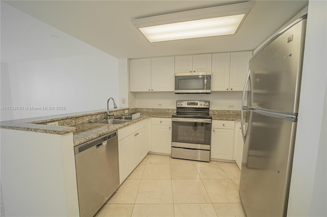 kitchen featuring sink, appliances with stainless steel finishes, light stone countertops, white cabinets, and kitchen peninsula