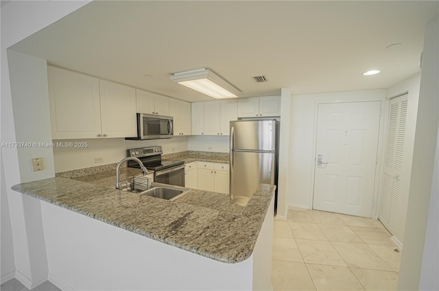 kitchen with sink, kitchen peninsula, stainless steel appliances, light stone countertops, and white cabinets