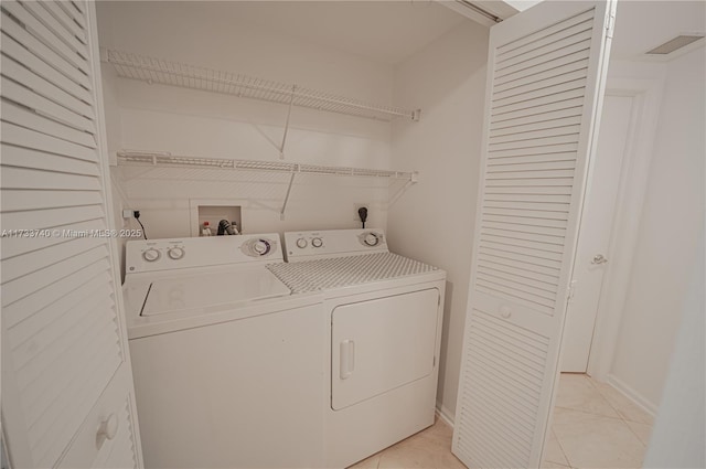 laundry area featuring separate washer and dryer and light tile patterned floors