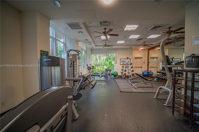 workout area featuring ceiling fan and a drop ceiling