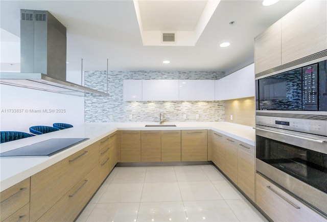 kitchen featuring white cabinetry, sink, decorative backsplash, island exhaust hood, and stainless steel appliances