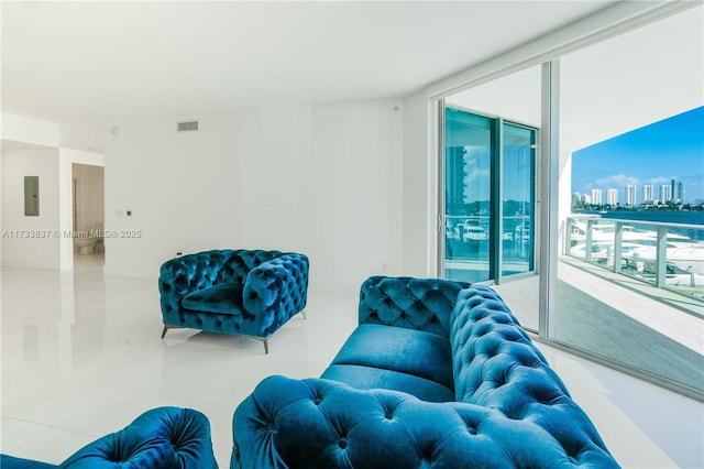 tiled living room featuring electric panel and expansive windows