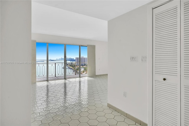 spare room featuring a water view and light tile patterned flooring