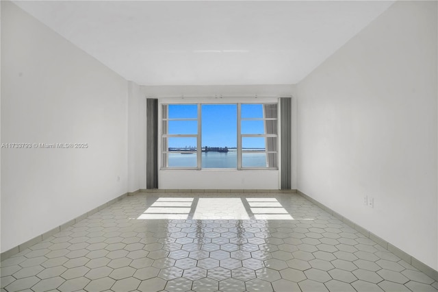 unfurnished room featuring a water view