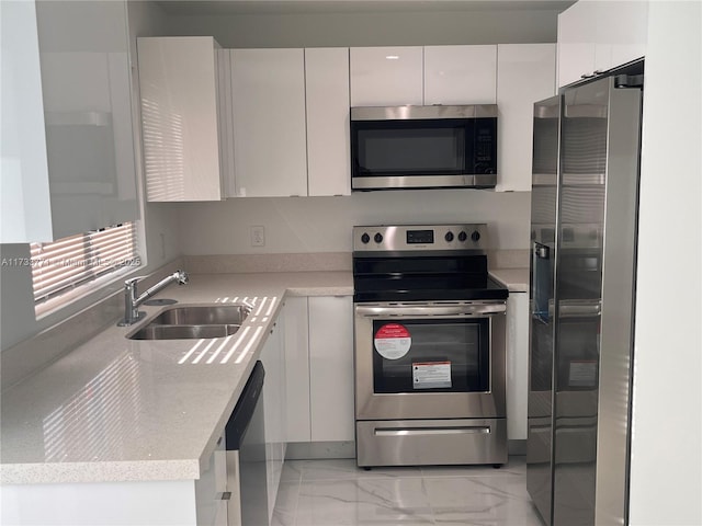 kitchen with stainless steel appliances, sink, and white cabinets