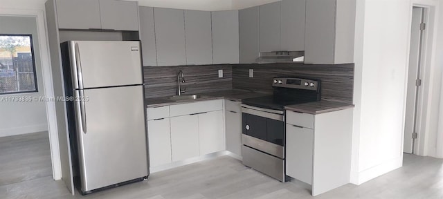 kitchen featuring light wood-type flooring, appliances with stainless steel finishes, sink, and gray cabinetry