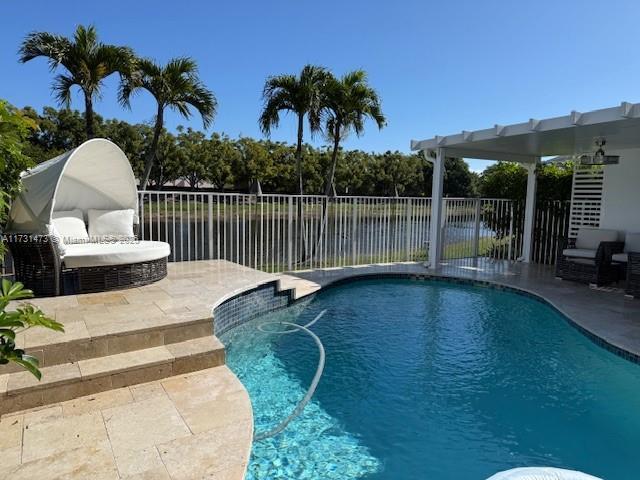 view of pool featuring a water view and a patio area