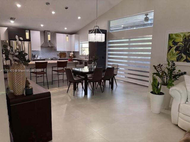 dining area with high vaulted ceiling