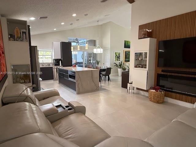 living room featuring high vaulted ceiling and a textured ceiling