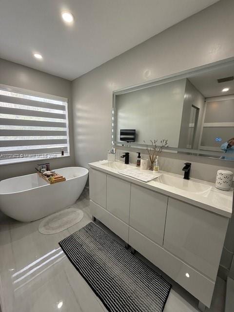 bathroom featuring a washtub and vanity