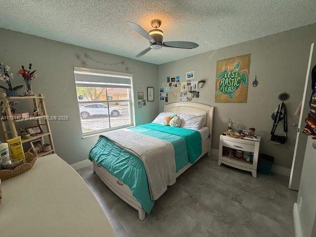 bedroom with ceiling fan and a textured ceiling