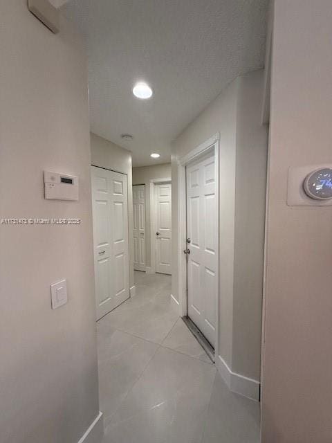 hall with light tile patterned floors