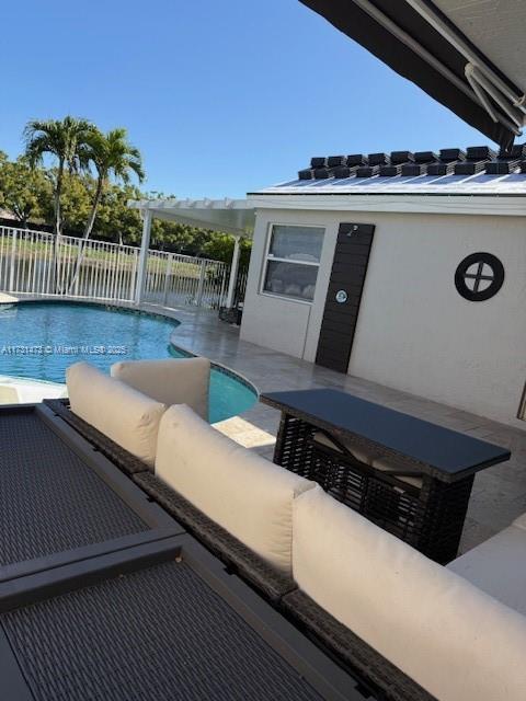 view of swimming pool featuring an outbuilding, outdoor lounge area, a patio, and pool water feature