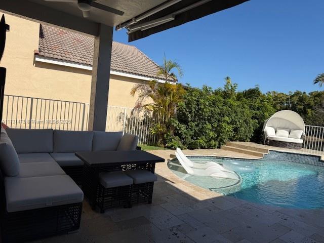 view of pool featuring ceiling fan, an outdoor living space, and a patio