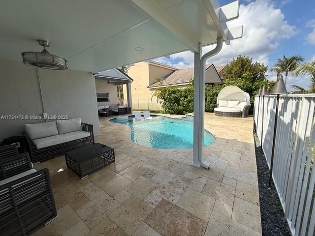 view of swimming pool featuring an outdoor living space, a patio area, and ceiling fan