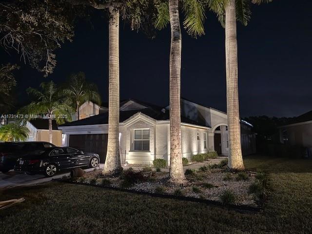 property exterior at twilight featuring a yard