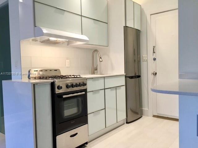 kitchen featuring backsplash, stainless steel appliances, and sink