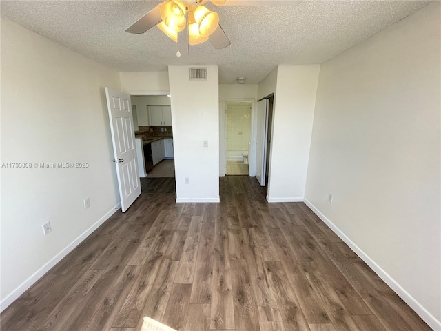 unfurnished room featuring ceiling fan, dark hardwood / wood-style floors, and a textured ceiling