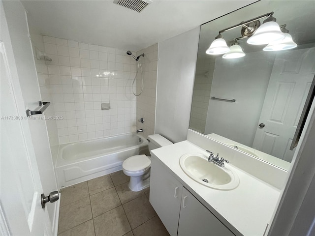 full bathroom with tile patterned flooring, vanity, tiled shower / bath combo, and toilet