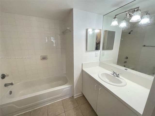 bathroom featuring tile patterned flooring, tiled shower / bath, and vanity