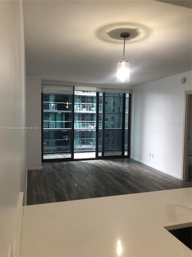 empty room featuring dark hardwood / wood-style floors and expansive windows