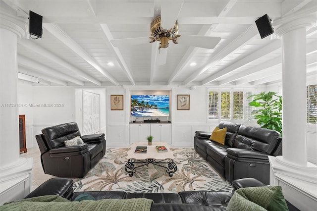 living room featuring ornate columns, ceiling fan, and beamed ceiling