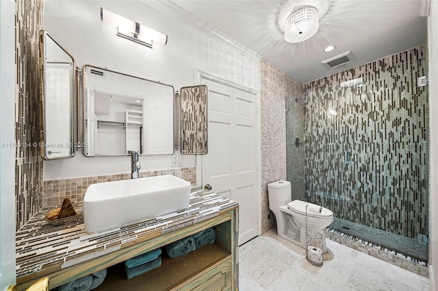 bathroom featuring a tile shower, backsplash, vanity, and toilet