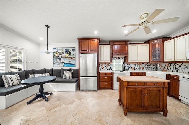 kitchen with pendant lighting, tasteful backsplash, sink, crown molding, and white appliances