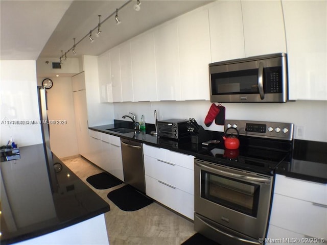 kitchen featuring white cabinetry, stainless steel appliances, and a sink