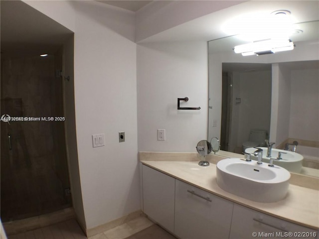 bathroom with a stall shower, vanity, toilet, and tile patterned floors