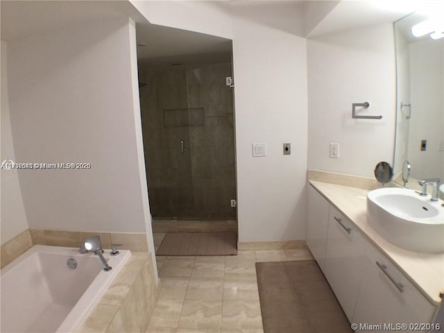 bathroom featuring a garden tub, vanity, a shower stall, and tile patterned floors