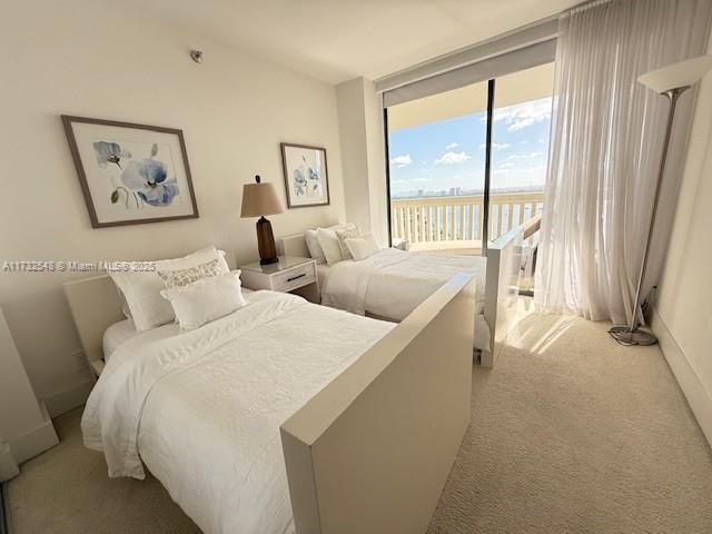 carpeted bedroom with access to exterior and floor to ceiling windows