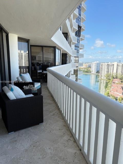 balcony featuring a water view and a city view