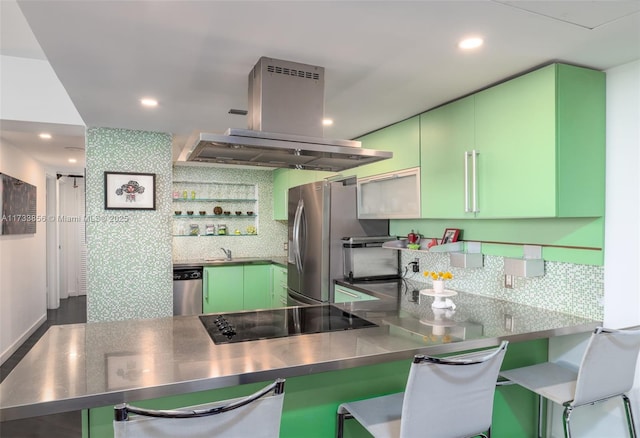 kitchen featuring a breakfast bar area, stainless steel counters, kitchen peninsula, island exhaust hood, and stainless steel appliances