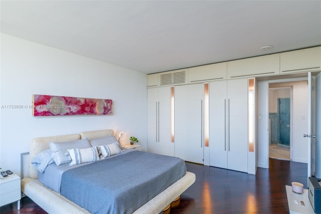 bedroom with dark hardwood / wood-style floors and a closet