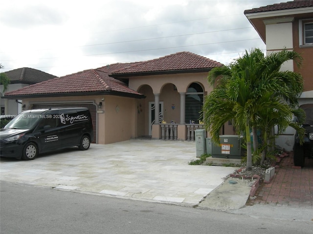 mediterranean / spanish-style home featuring central AC and a garage