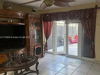 doorway to outside featuring a wealth of natural light, light tile patterned floors, and ceiling fan