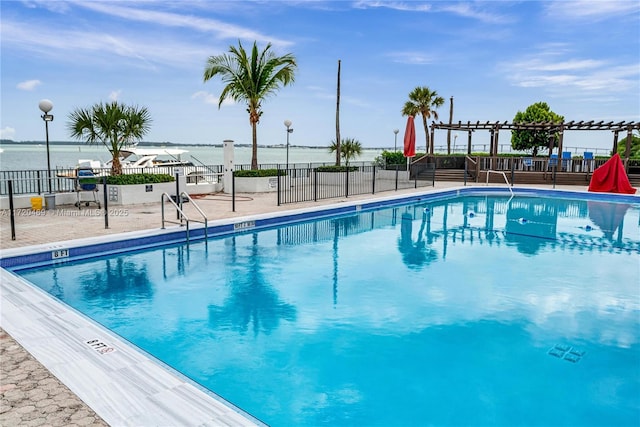 view of swimming pool featuring a pergola, a patio area, and a water view