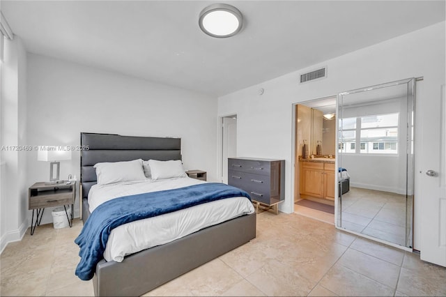 bedroom with light tile patterned flooring and connected bathroom