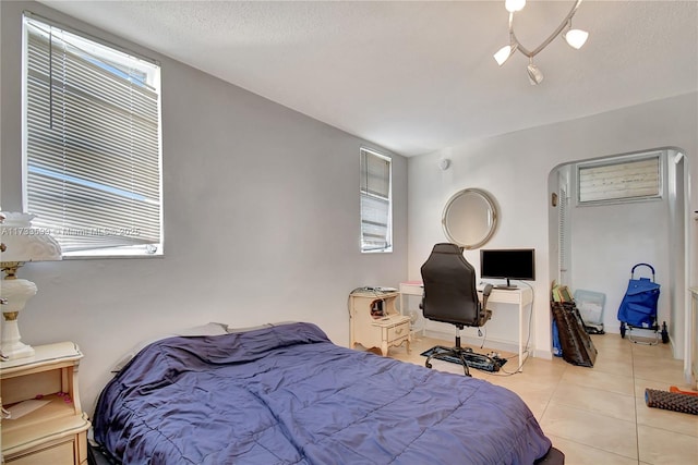 bedroom featuring light tile patterned floors and a textured ceiling