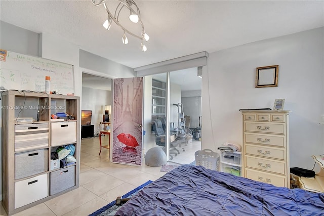 bedroom featuring light tile patterned flooring and a textured ceiling