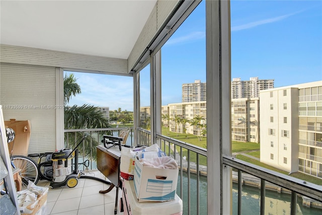 sunroom featuring a water view