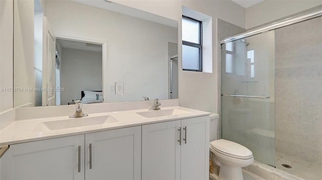 bathroom with vanity, toilet, and a shower with shower door