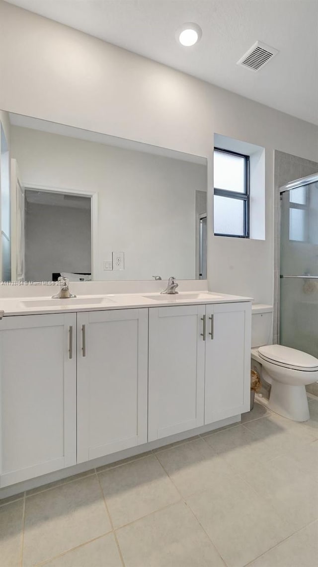 bathroom with vanity, toilet, an enclosed shower, and tile patterned flooring