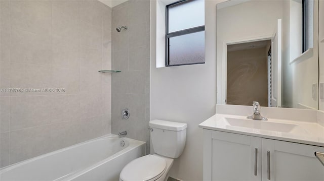 full bathroom featuring vanity, tiled shower / bath, and toilet