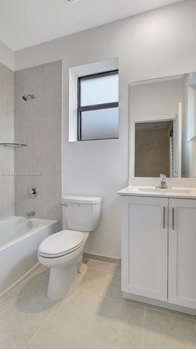 full bathroom featuring vanity, tile patterned flooring, tiled shower / bath combo, and toilet