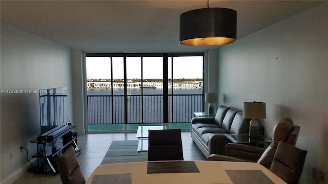 tiled living area featuring a wall of windows and baseboards