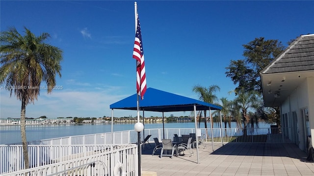 surrounding community with a water view, a patio area, and fence