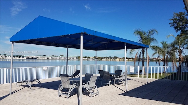 view of patio / terrace featuring a water view and fence